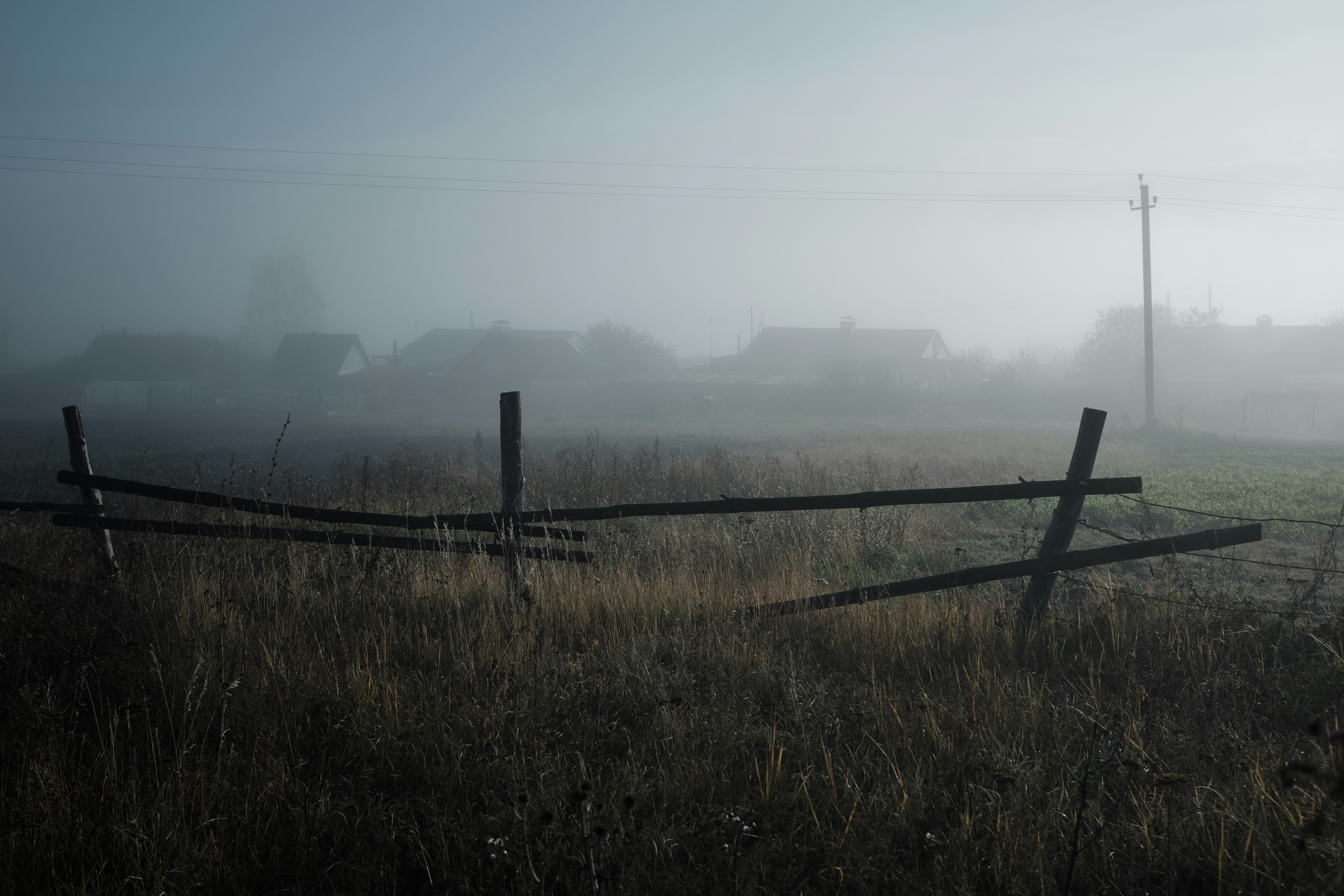 brown wooden fence on green grass field during daytime