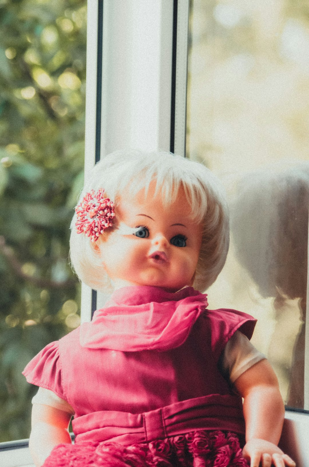 baby in red shirt standing near window