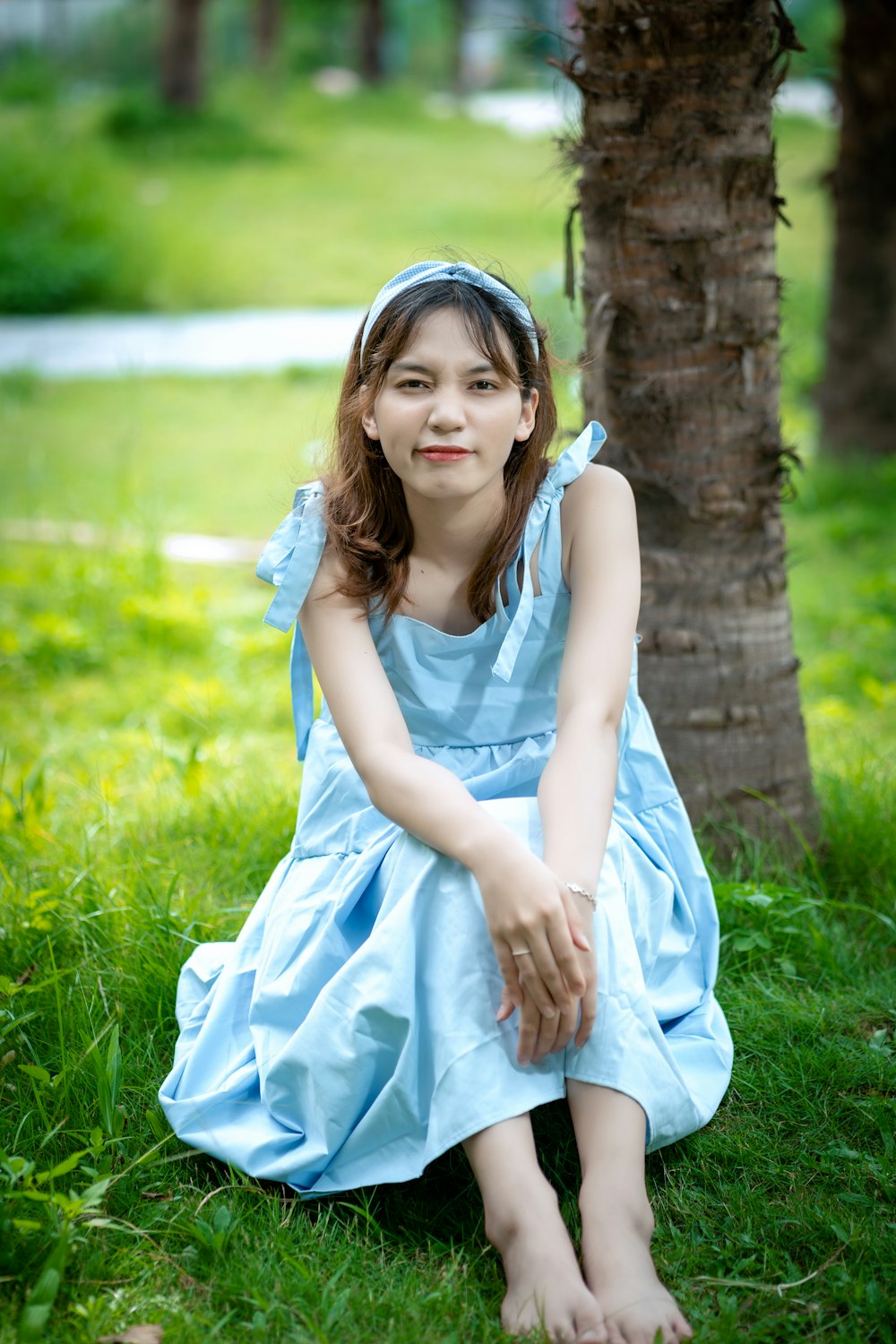 girl in white sleeveless dress sitting on green grass field