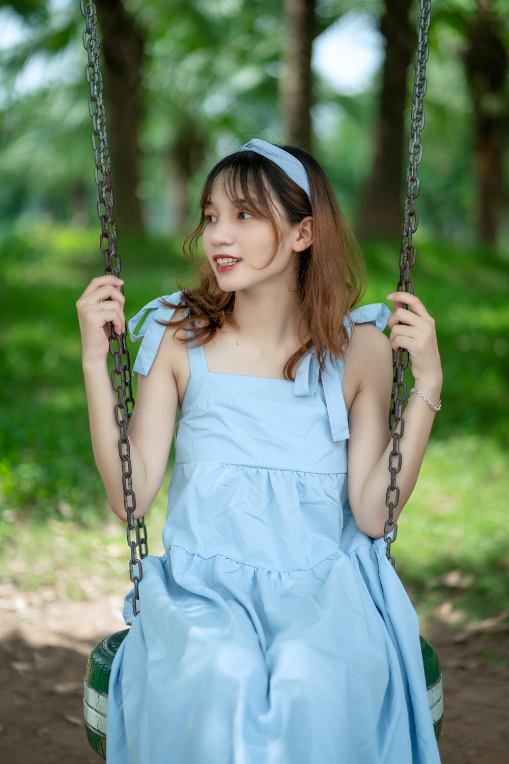 girl in white dress sitting on swing