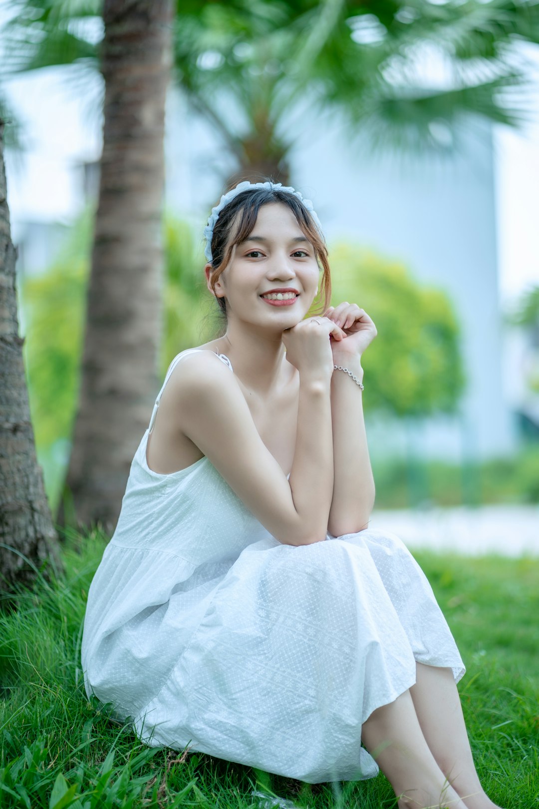 woman in white dress sitting on green grass during daytime