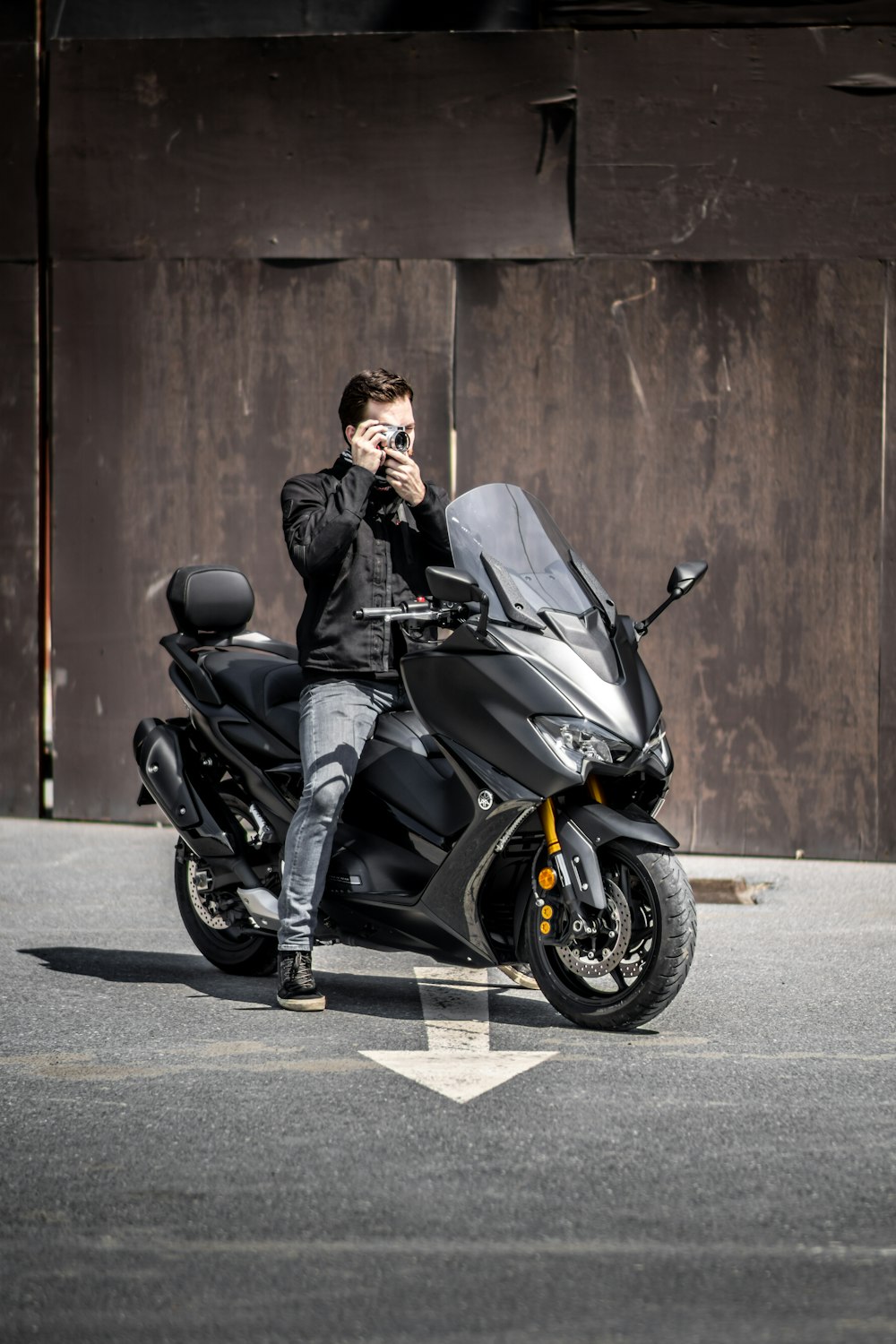 man in black jacket and black pants sitting on black motorcycle