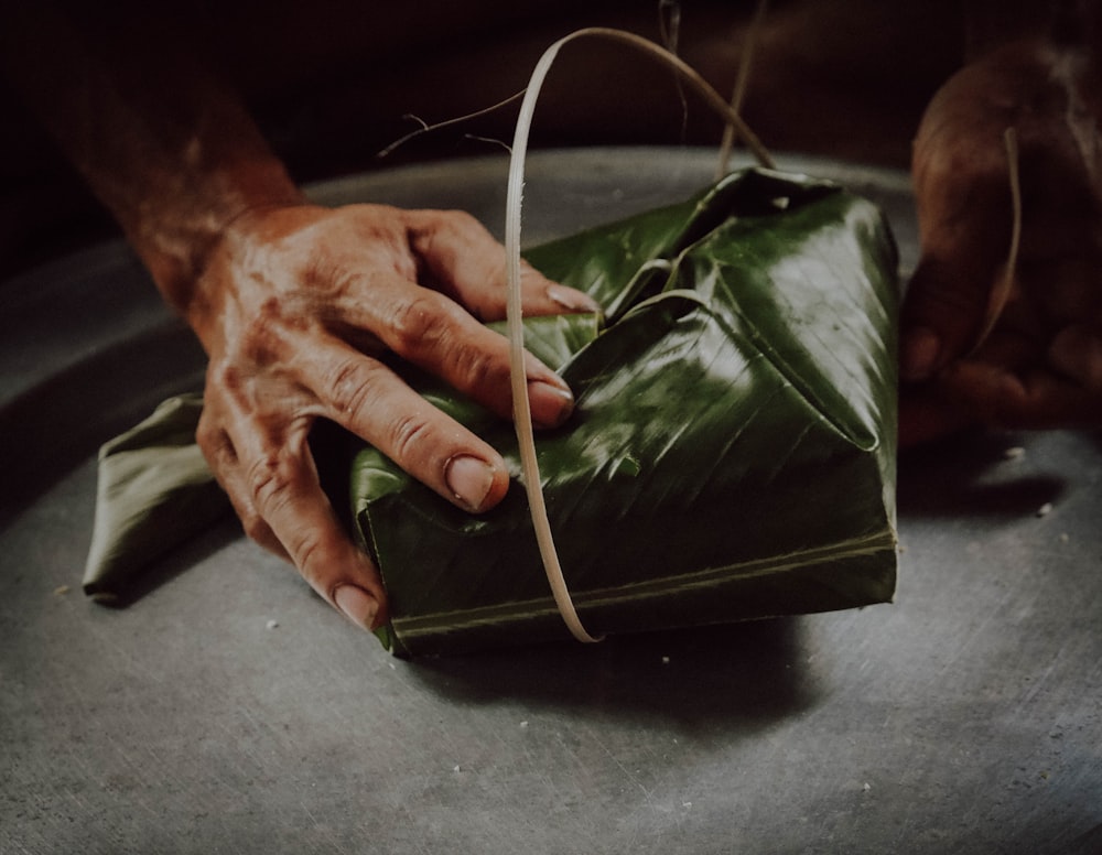 person holding black leather bag