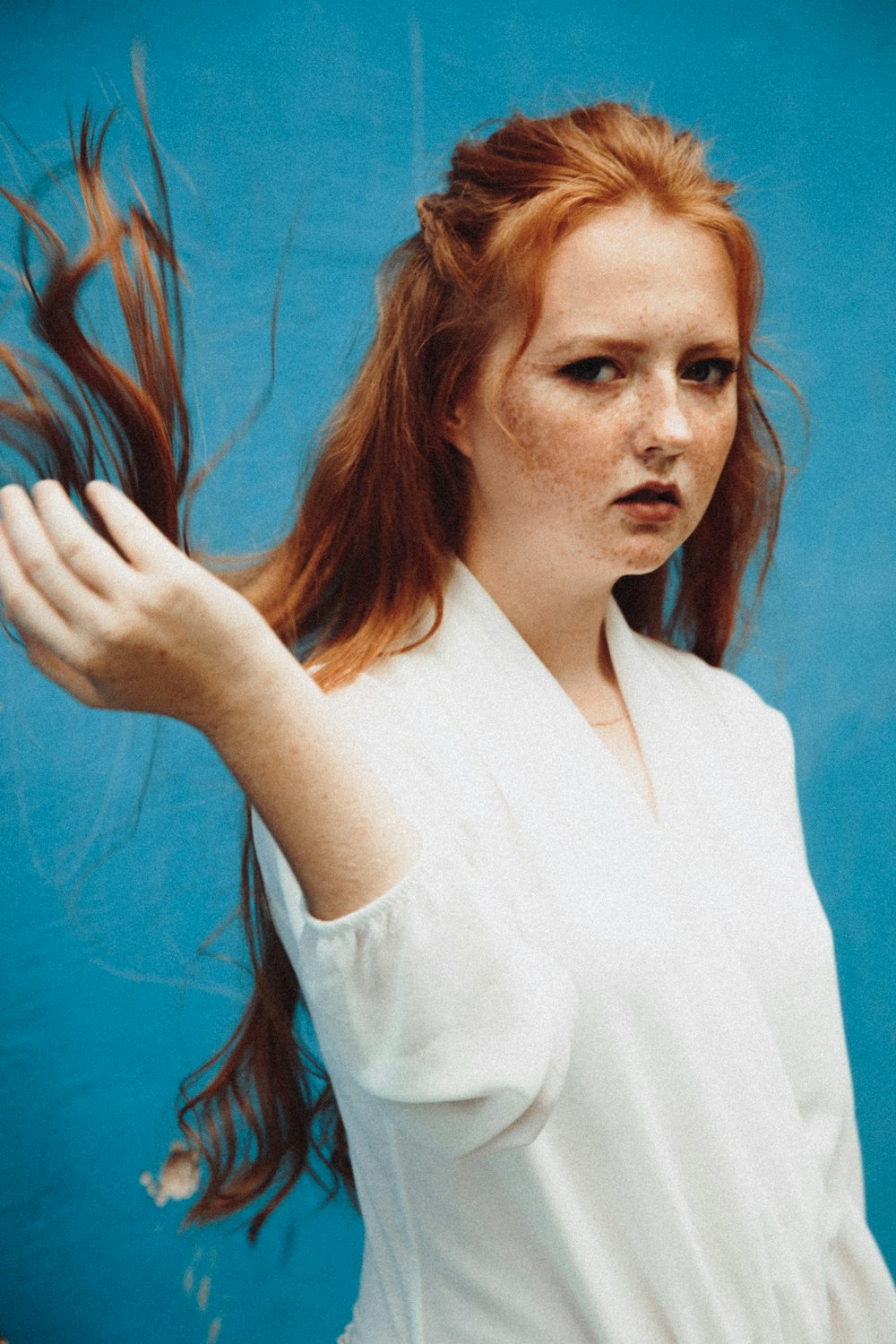 woman in white shirt holding her hair