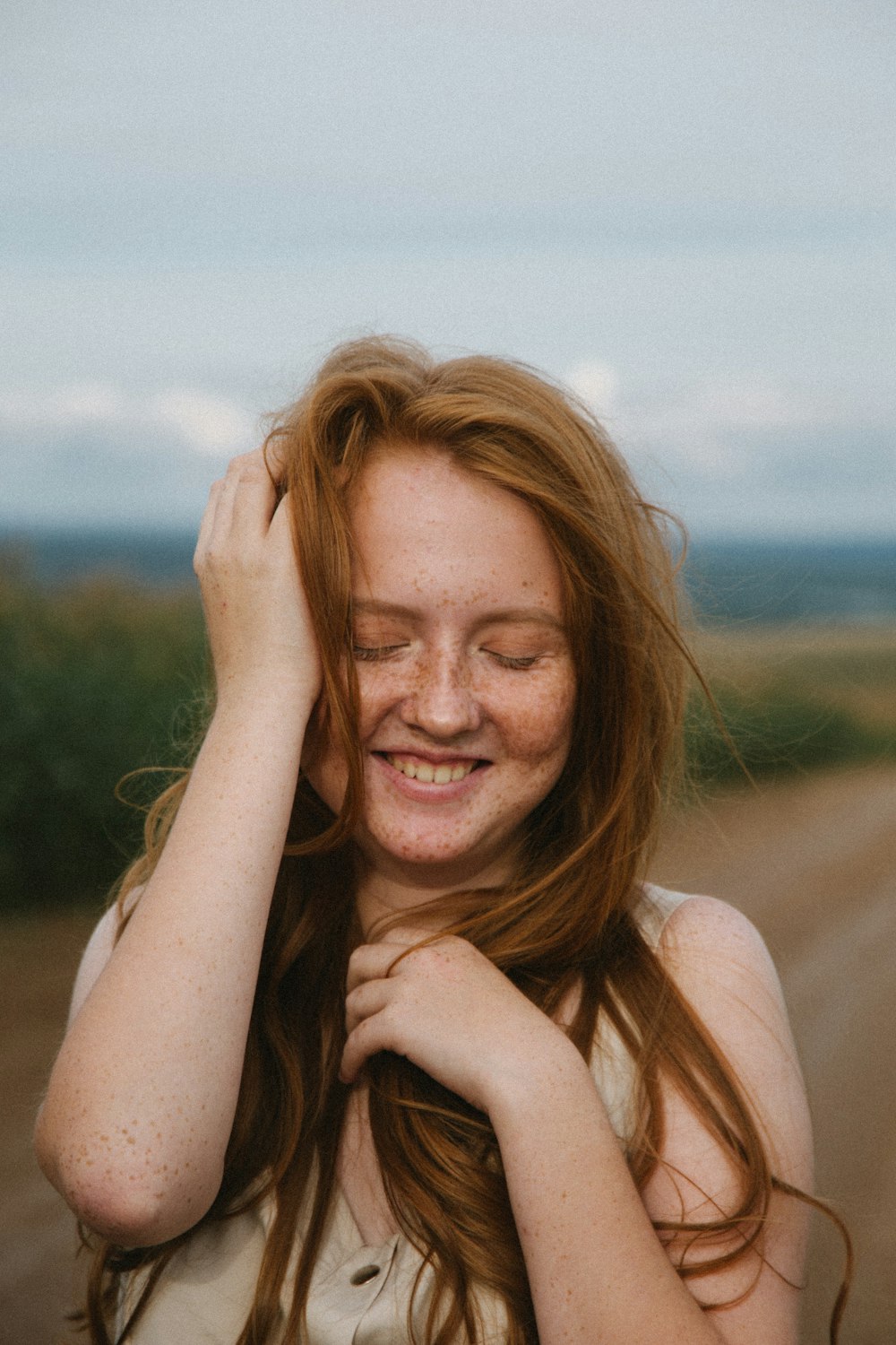 woman in white tank top smiling