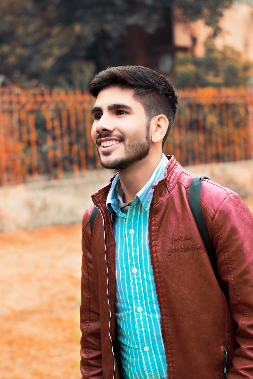 man in brown leather jacket standing during daytime