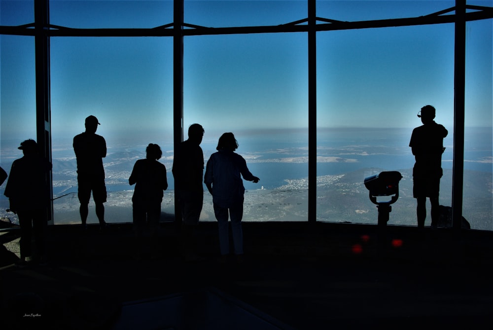 silhouette of people standing on dock during daytime