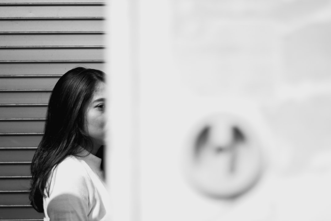 woman in white shirt standing near window