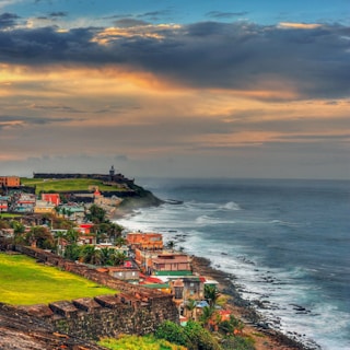houses near sea under cloudy sky during daytime