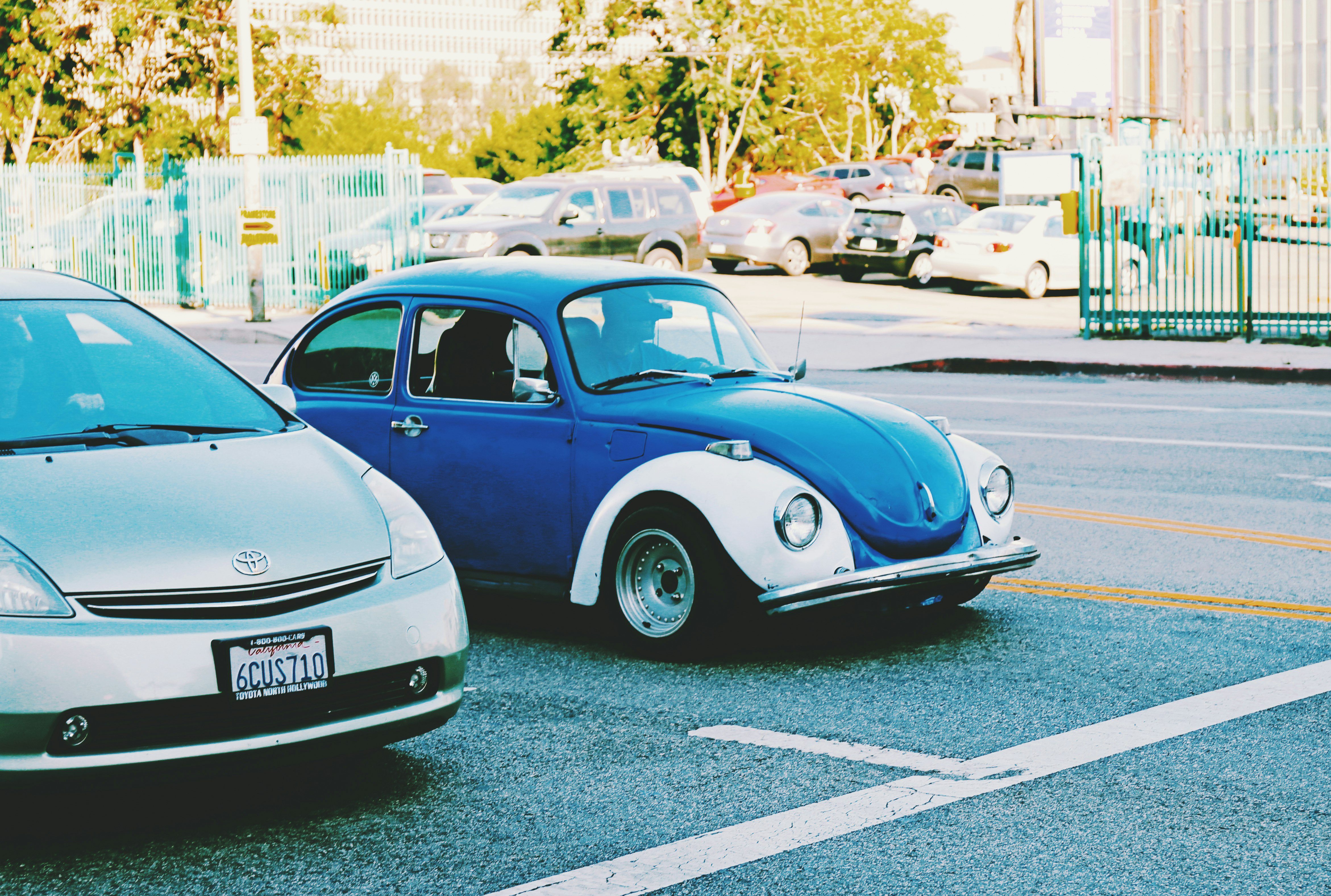 blue volkswagen beetle parked on parking lot during daytime