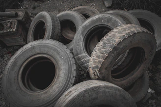 Stack of various second-hand tires neatly arranged in the workshop.