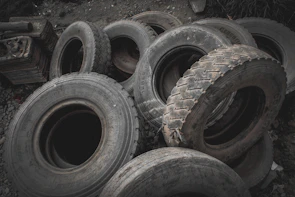 Stack of various truck tires ready for installation in a workshop.