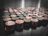 A stack of modern coins glinting under soft light, highlighting their metallic textures.