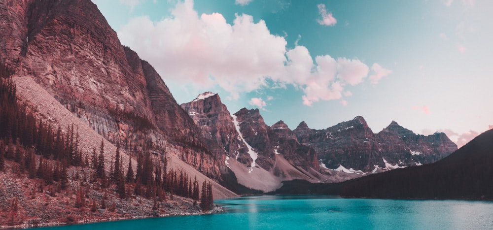 lake near mountain under blue sky during daytime