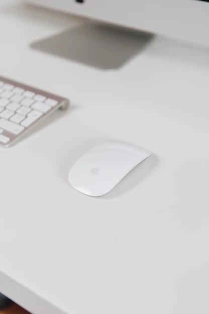 A sleek wireless keyboard and mouse set glowing softly on a clean desk.