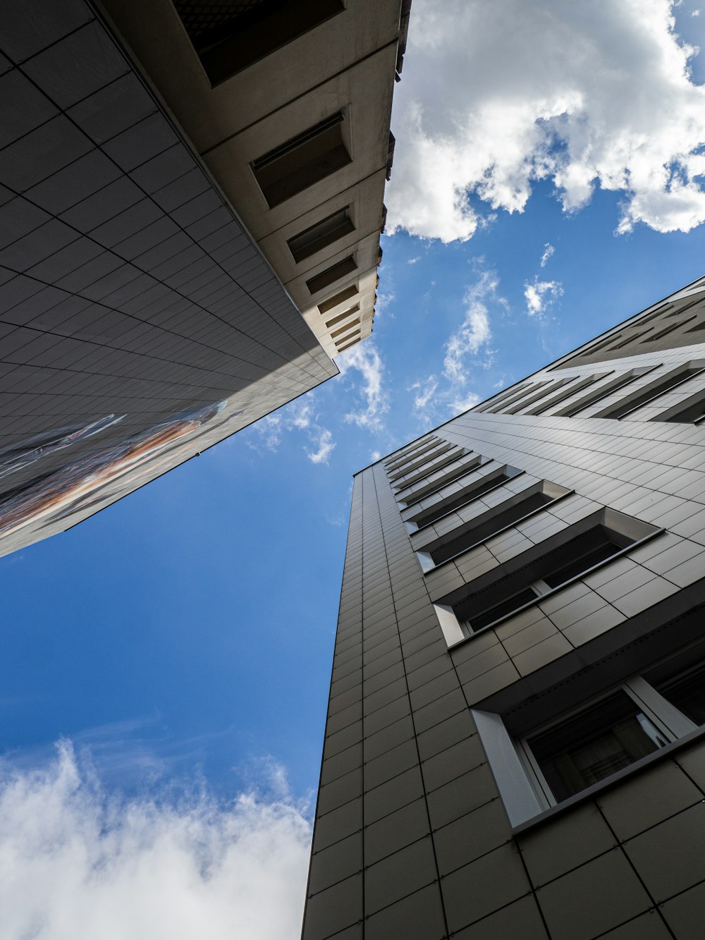 edificio in cemento bianco e grigio sotto il cielo blu durante il giorno