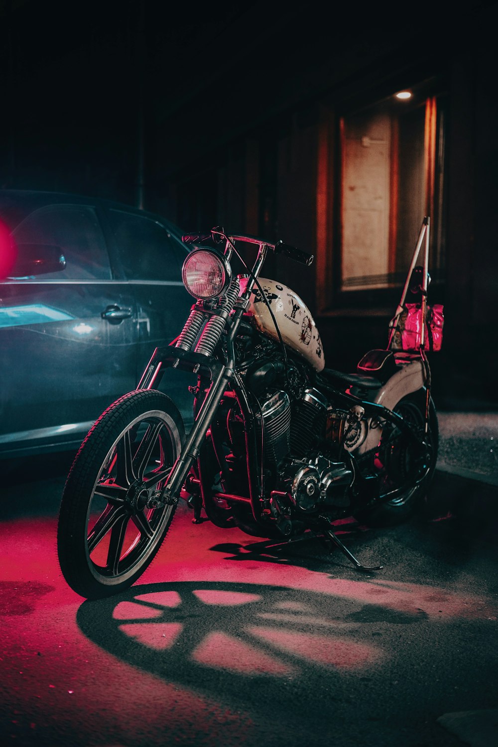 black and red motorcycle parked beside black car