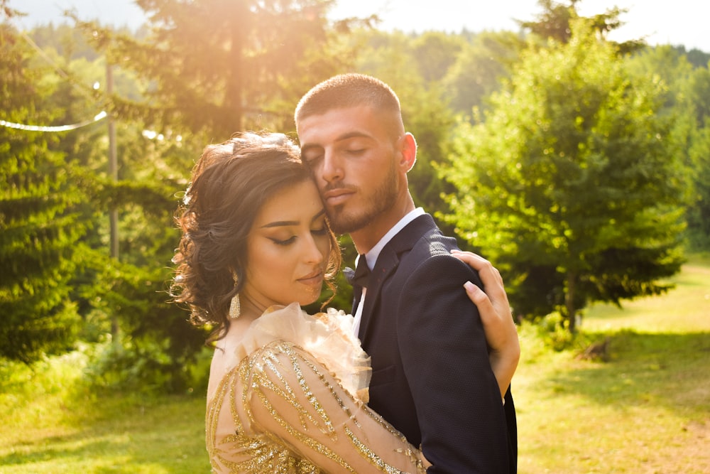 man in black suit kissing woman in white wedding dress