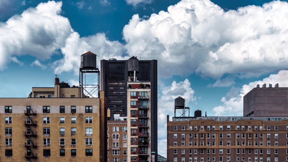 Braunes Betongebäude unter weißen Wolken und blauem Himmel tagsüber