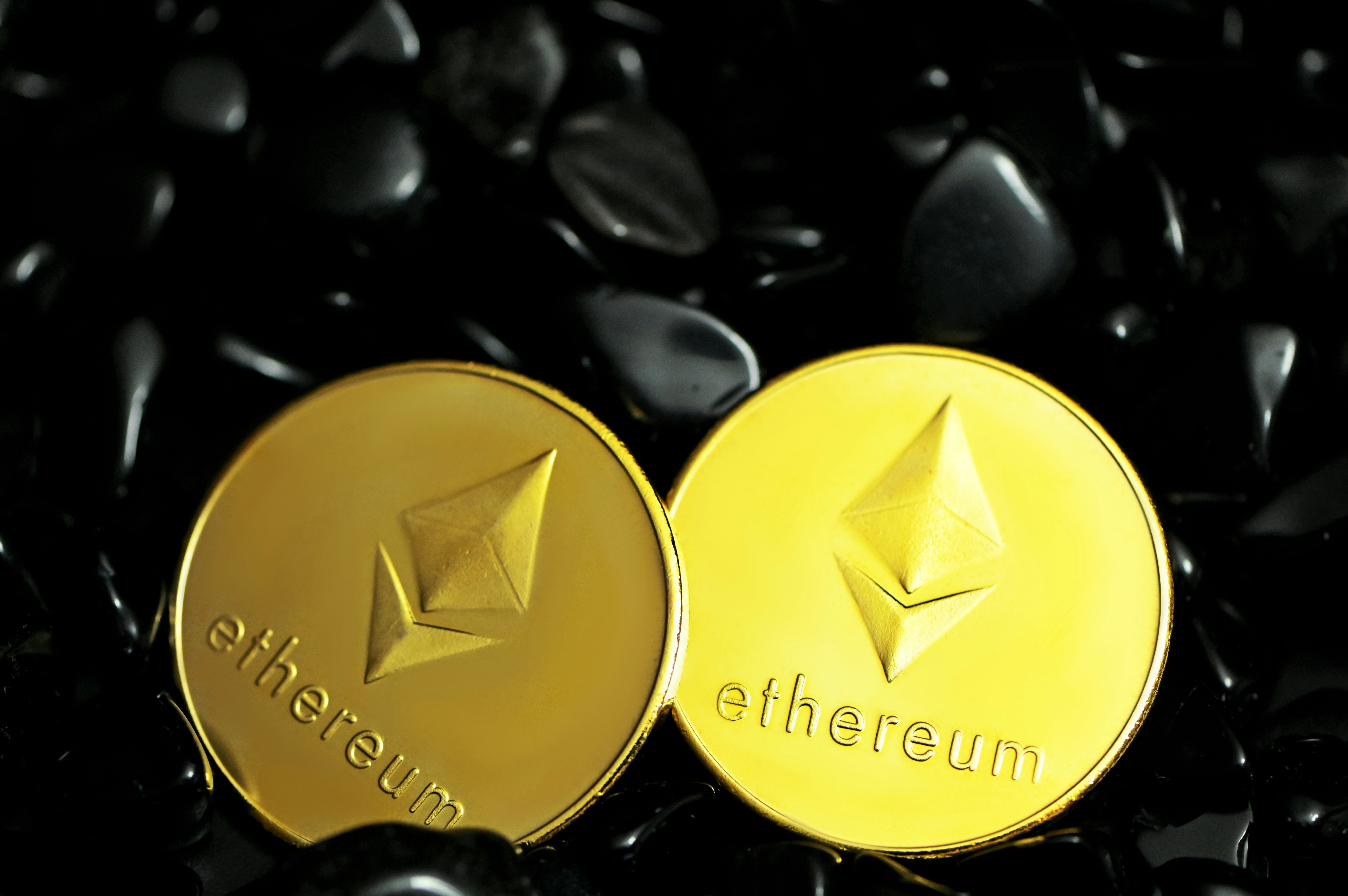 Two Ethereum coins on top of black stones