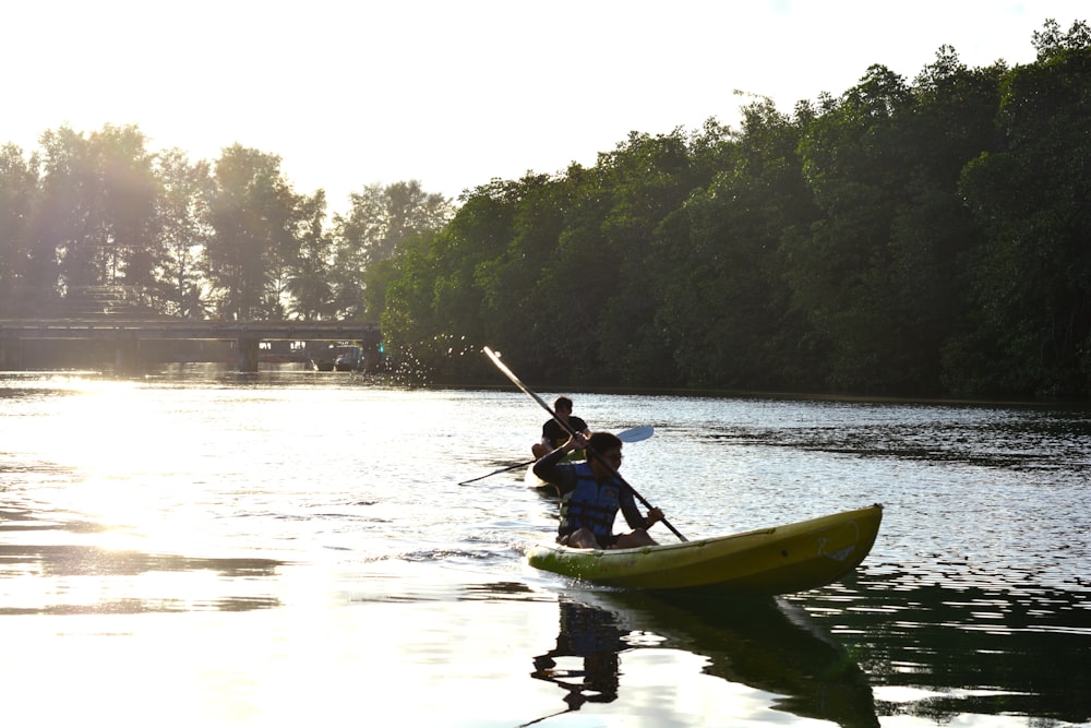 man riding on yellow kayak on river during daytime