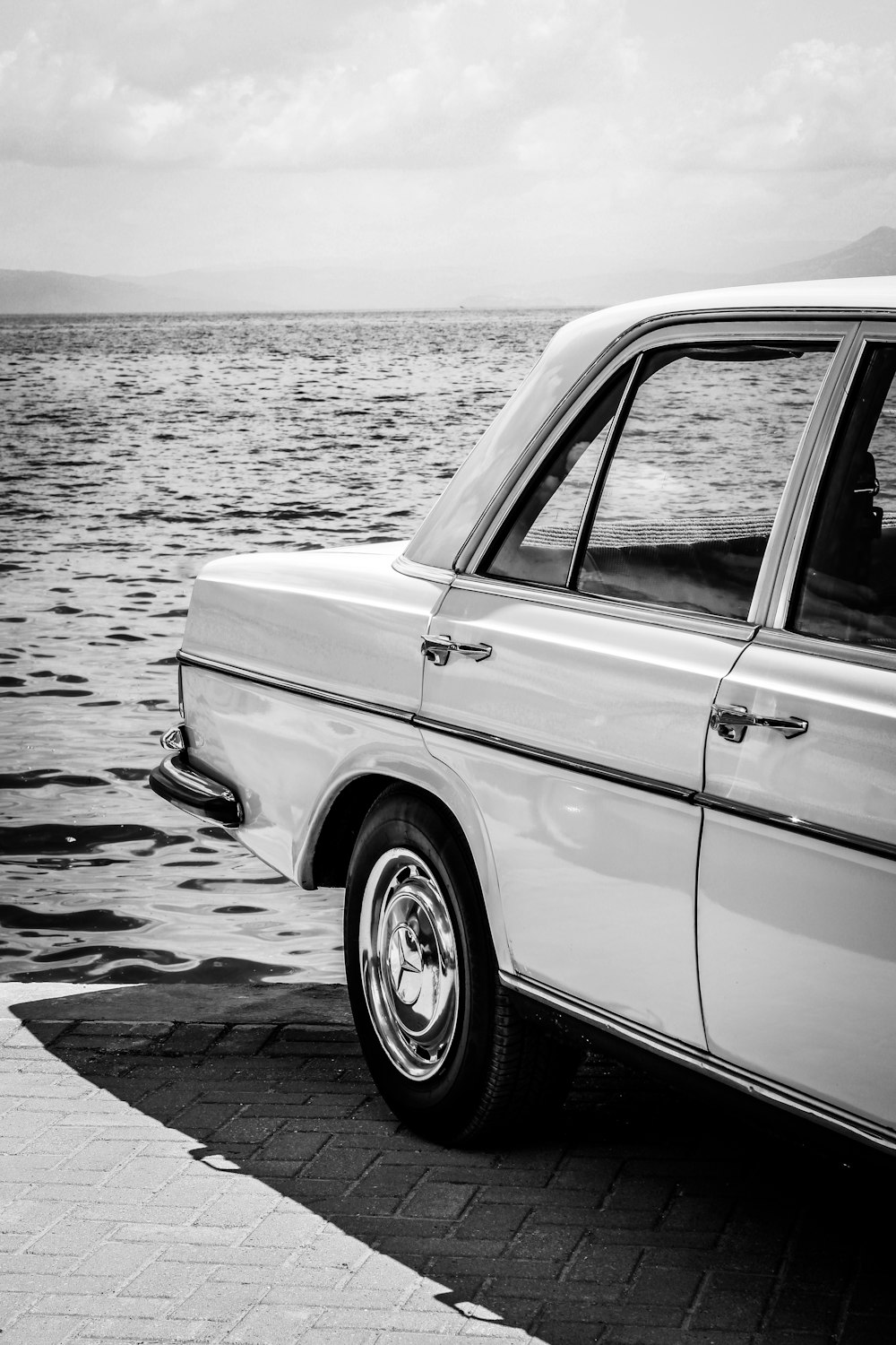 grayscale photo of car on beach