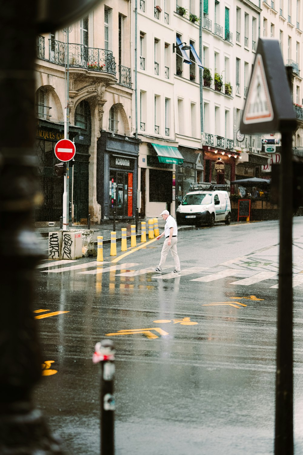 man in white long sleeve shirt and pants walking on pedestrian lane during daytime