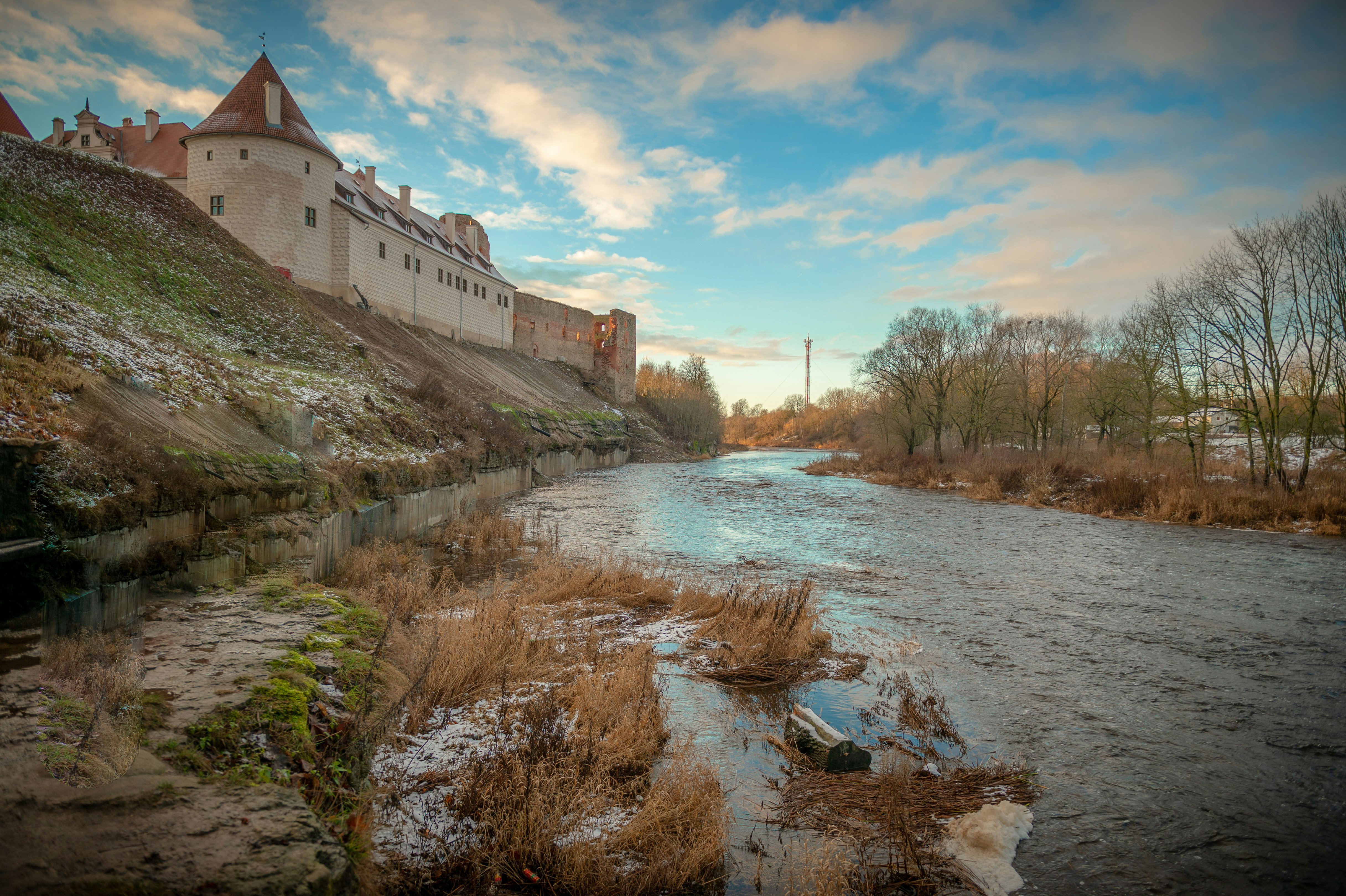 white concrete building near river under blue sky during daytime