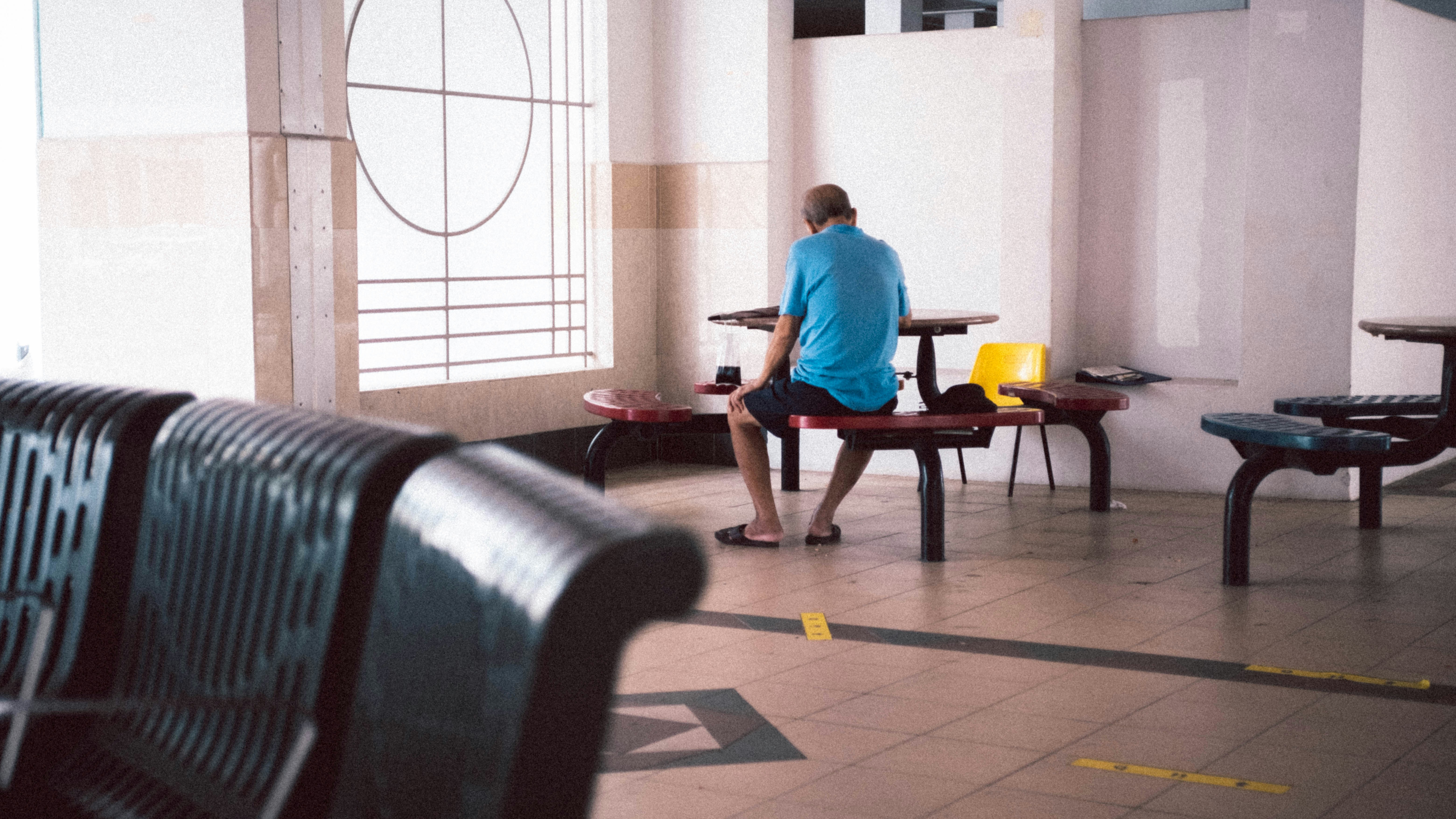 man in blue t-shirt sitting on chair