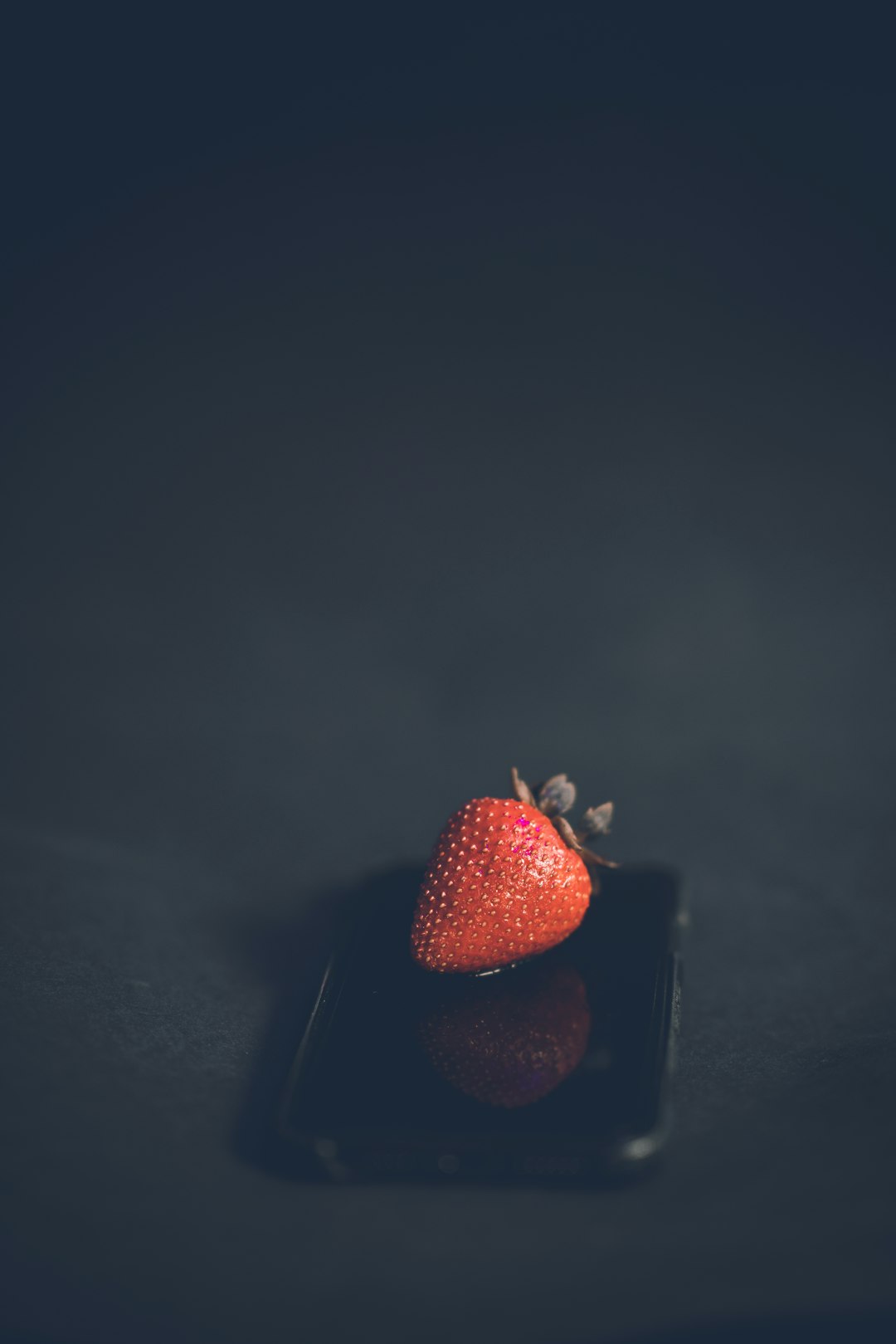 red strawberry fruit on black surface