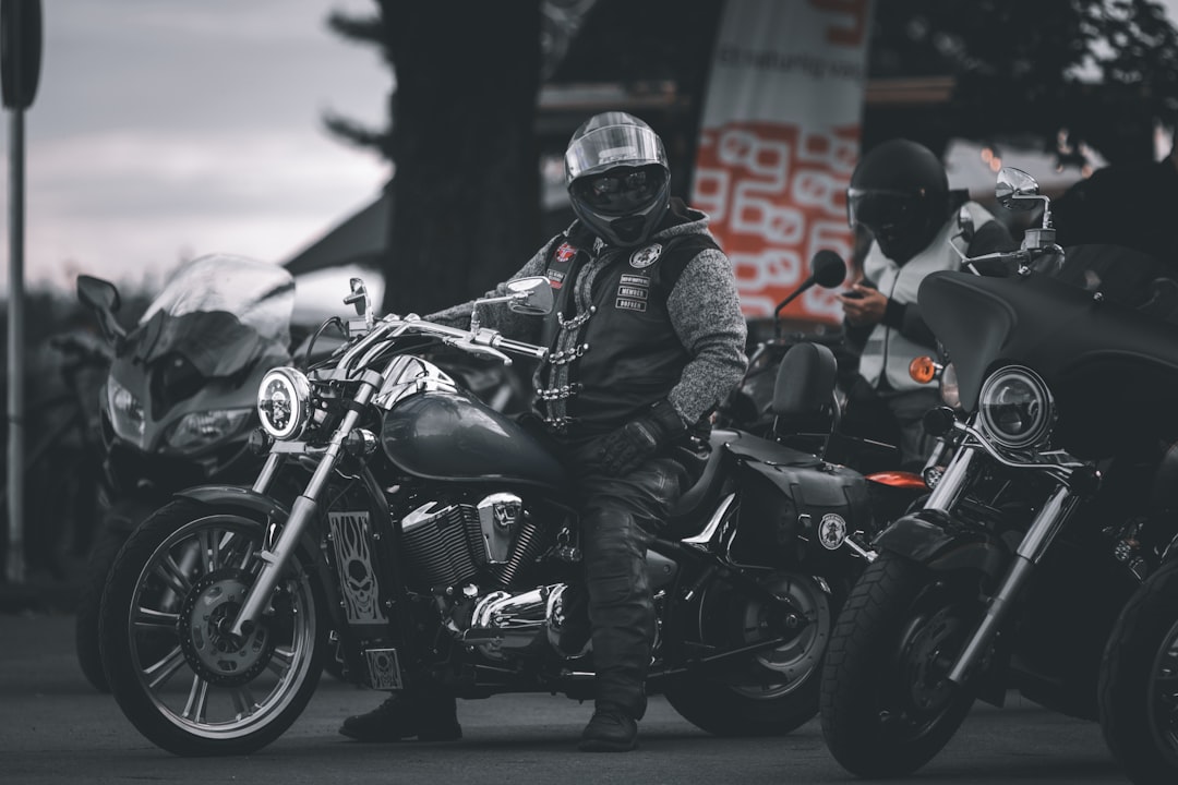 man in black leather jacket riding black motorcycle