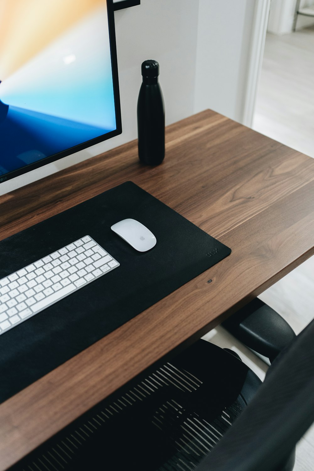 teclado da maçã prateada na mesa de madeira marrom