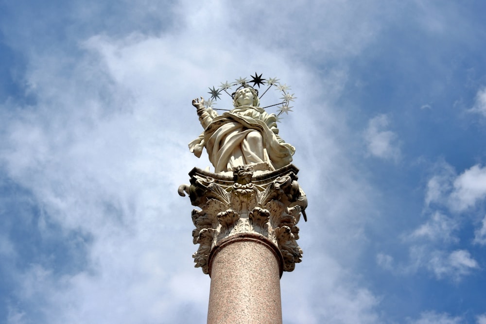 gold statue under white clouds during daytime