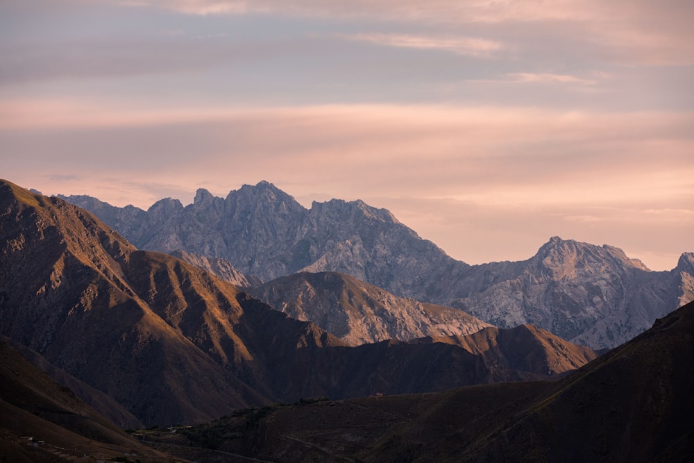 brown and green mountains under white clouds during daytime