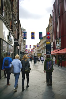 A vibrant city street bustling with people and colorful banners announcing local events.