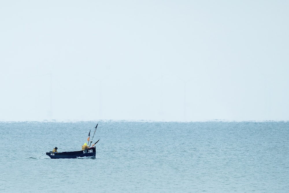 2 person riding on boat on sea during daytime