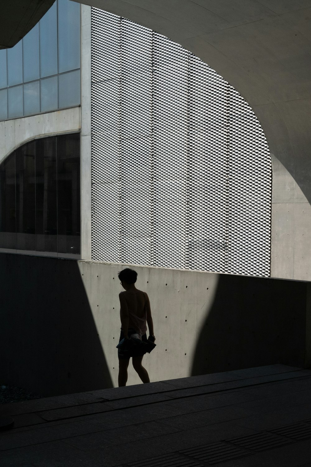 man in black t-shirt and black pants walking on sidewalk