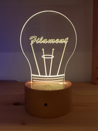 Close-up of a delicate acrylic LED lamp glowing softly beside a custom engraved plaque.