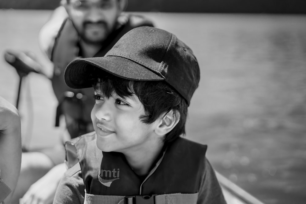 grayscale photo of boy wearing hat and coat