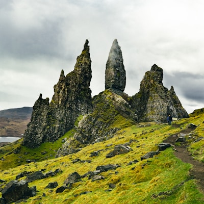 green and black rock formation under white clouds during daytime