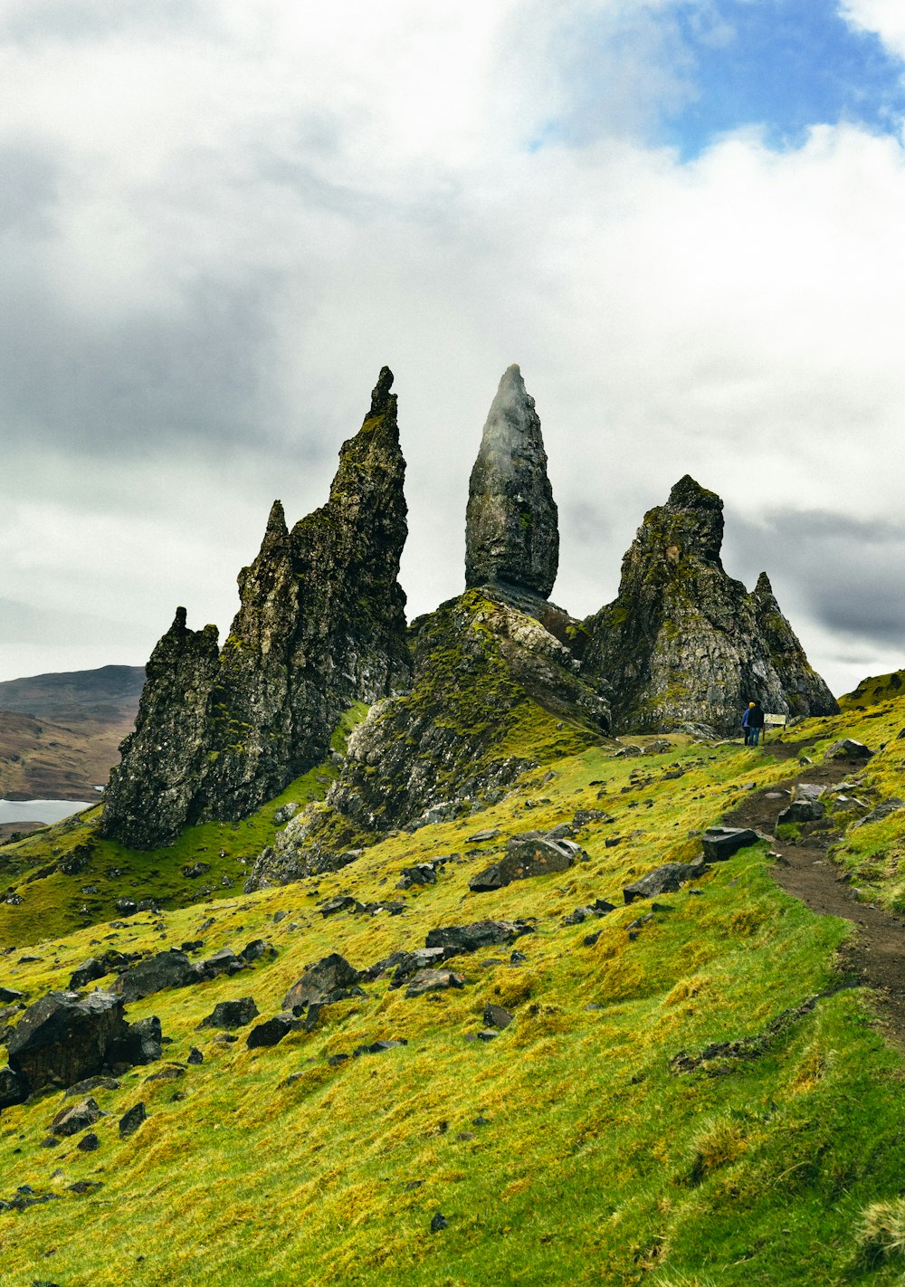 green and black rock formation under white clouds during daytime