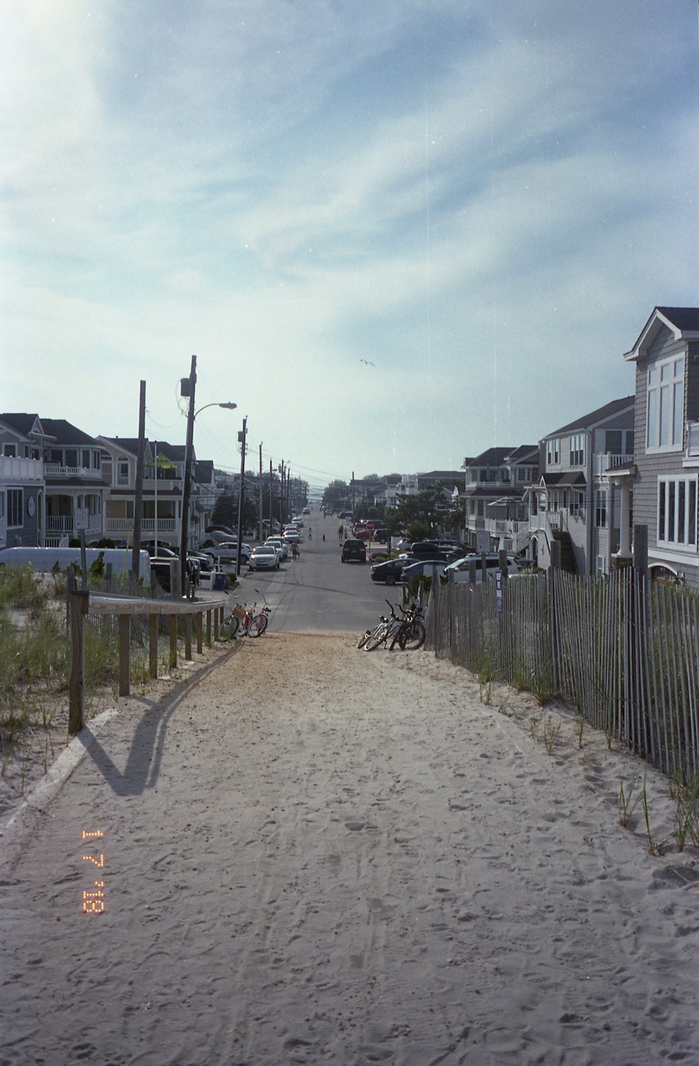 people walking on sidewalk near houses during daytime