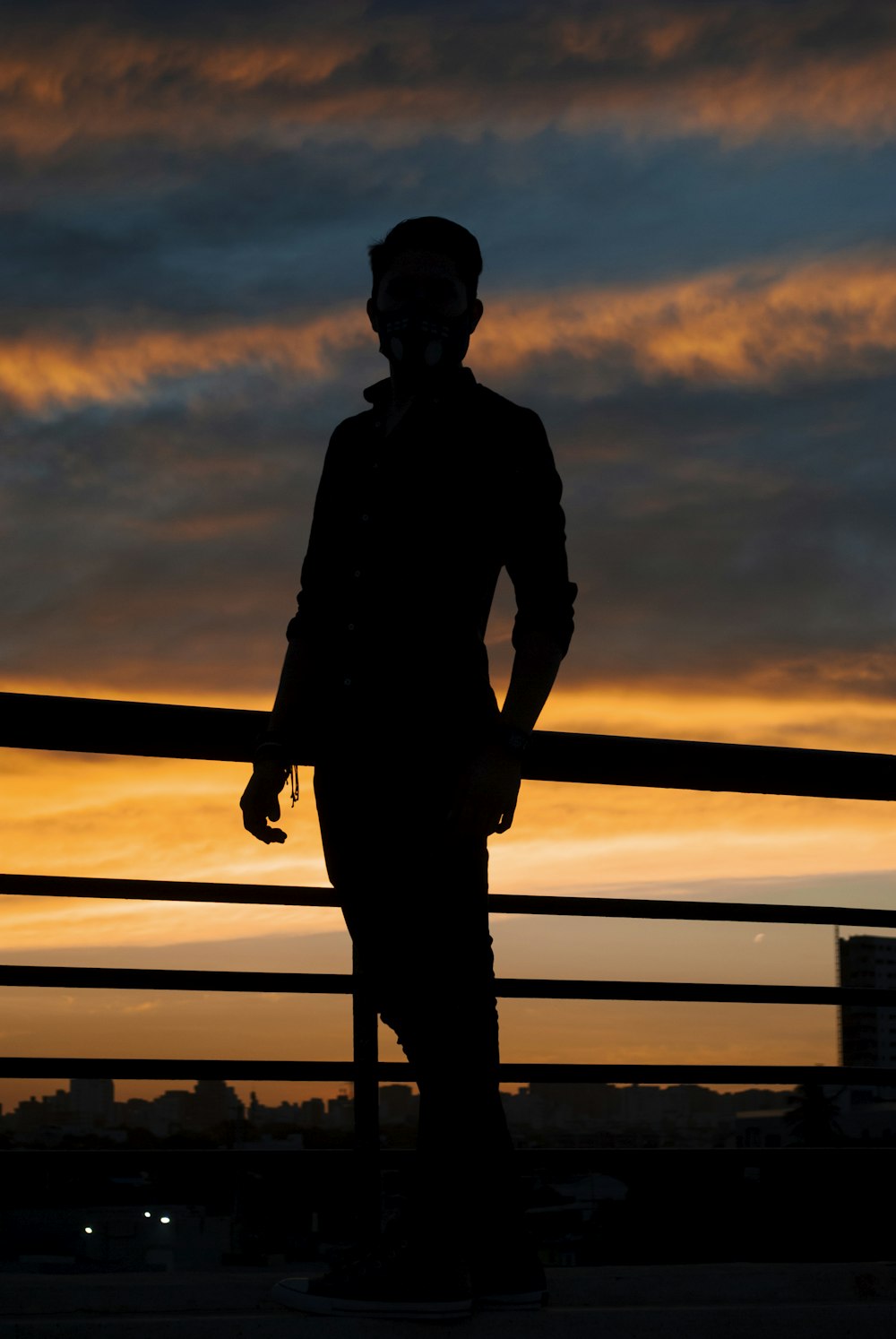 silhouette of man standing on wooden dock during sunset