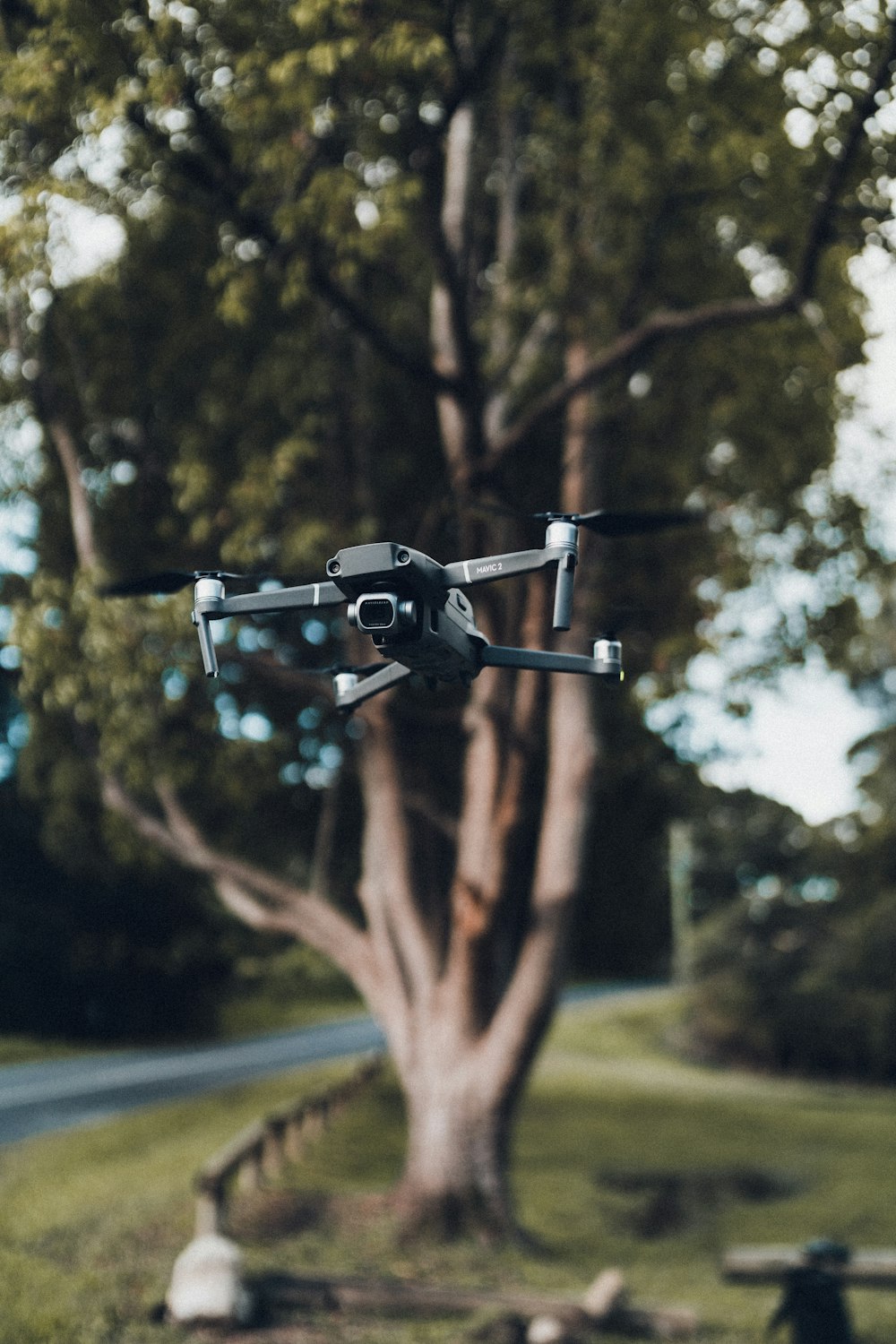 drone noir volant au-dessus des arbres verts pendant la journée