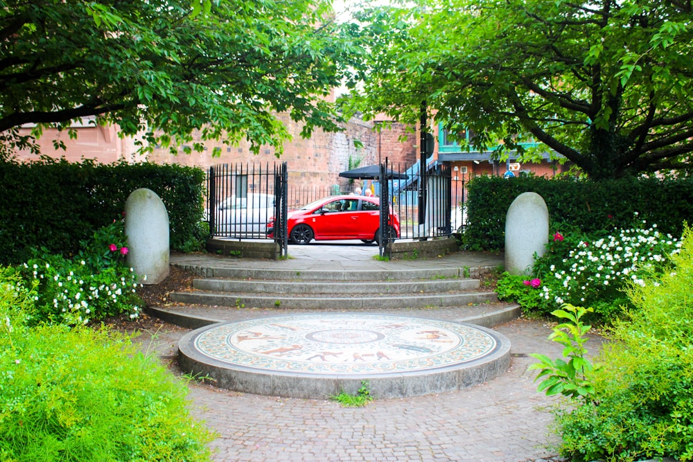 red car parked near white concrete gate