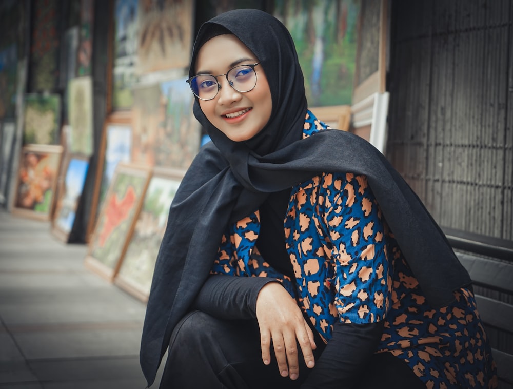 woman in black hijab and black white and orange floral long sleeve shirt