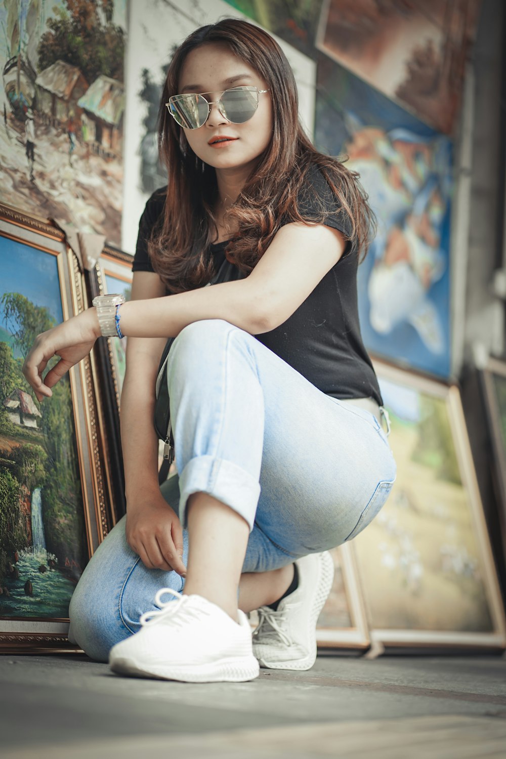 woman in black tank top and blue denim jeans sitting on window during daytime