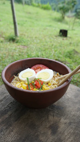 A rustic wooden table set with a steaming bowl of traditional Japanese ramen.