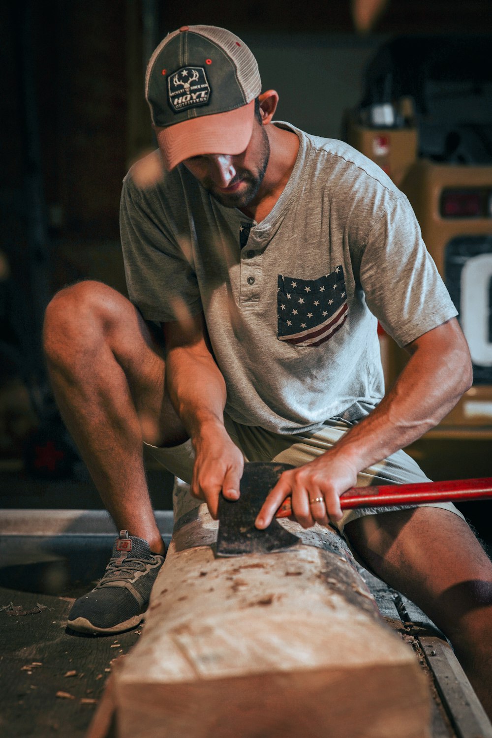 man in gray crew neck t-shirt and red cap sitting on brown wooden bench