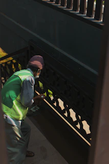 A team member carefully washing stair railings in a residential building.